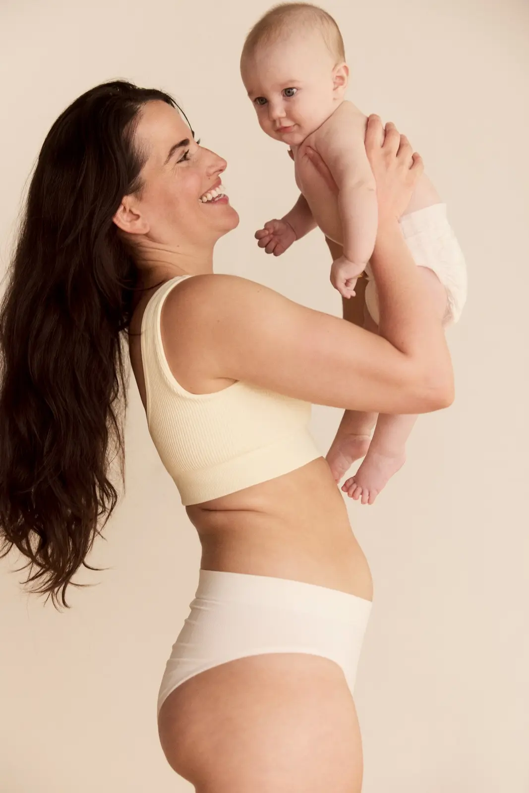 A mother lifting her baby